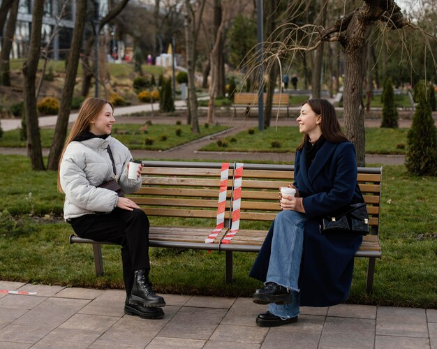 Women sitting at distance and wearing mask