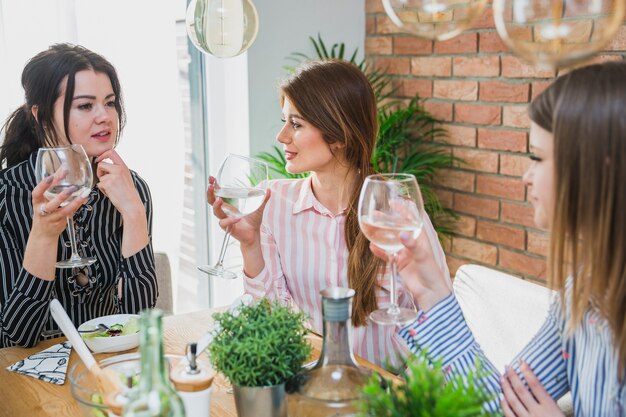 Women sitting at table holding glasses