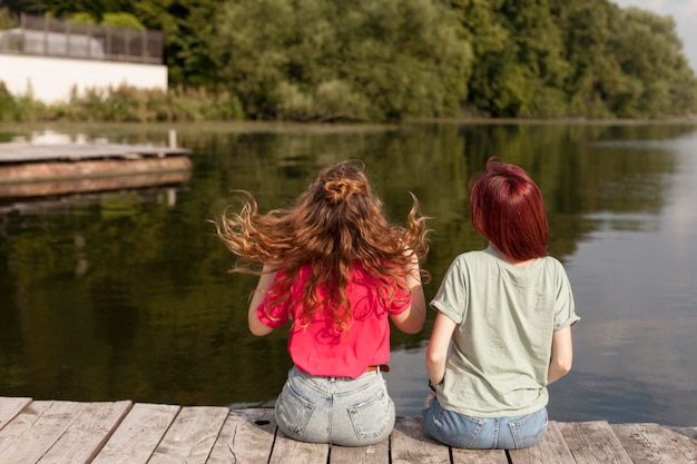 Free photo women staying on dock looking at lake