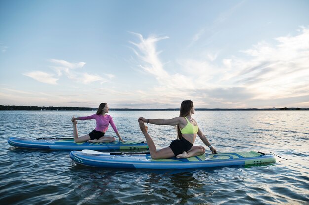 Women stretching on paddleboard side view