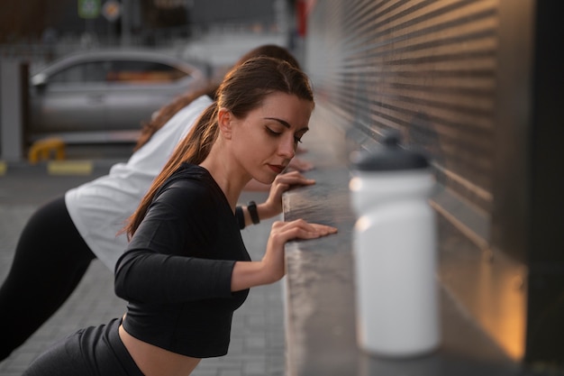 Women stretching together before working out outdoors