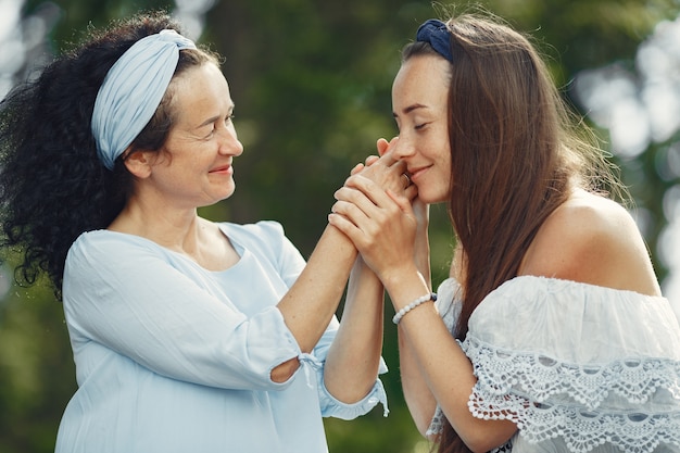 Women in a summer forest. Lady in a blue dress. Family posing and embracing.