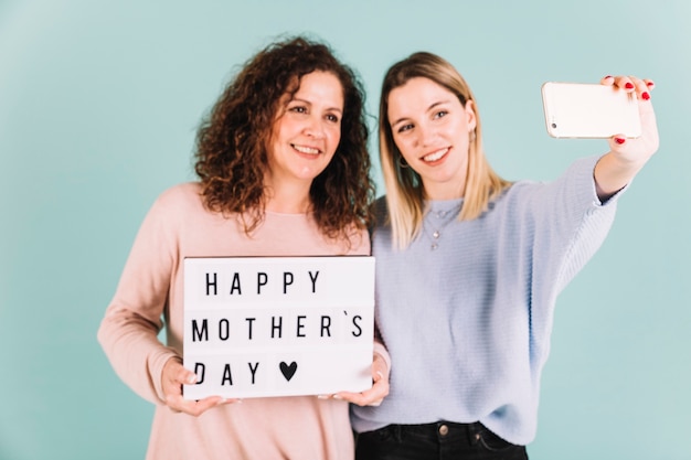 Free photo women taking selfie with mother's day greeting