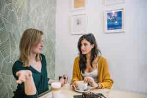 Free photo women talking and drinking coffe