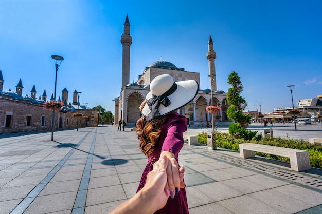 Free photo women tourists holding man's hand and leading him to mosque in konya, turkey.