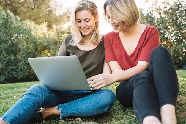 Women using laptop on ground