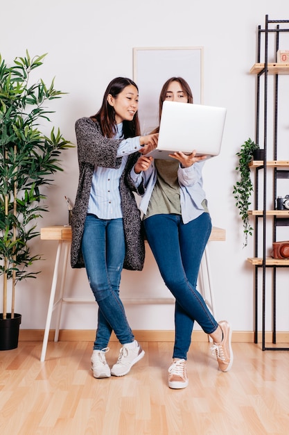 Women using laptop while coworking