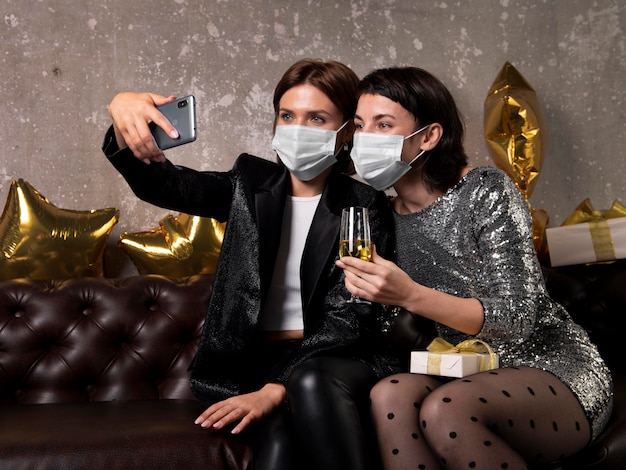 Women wearing face masks taking a selfie