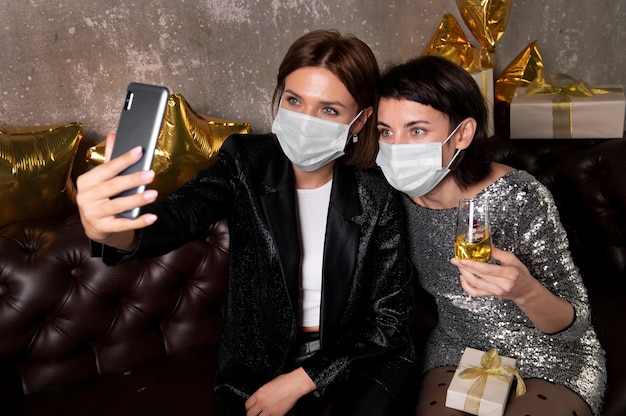 Women wearing face masks taking a selfie