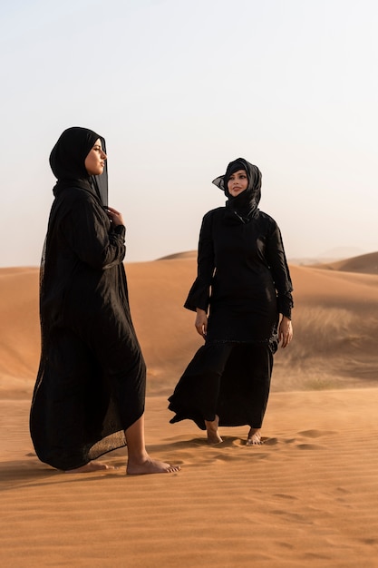 Free Photo women wearing hijab in the desert