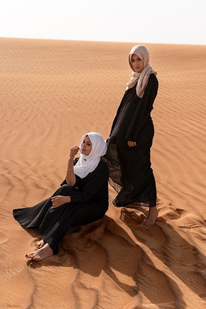 Free photo women wearing hijab in the desert