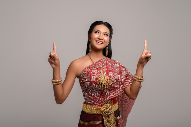 Free photo women wearing thai costumes that are symbolic, pointing fingers