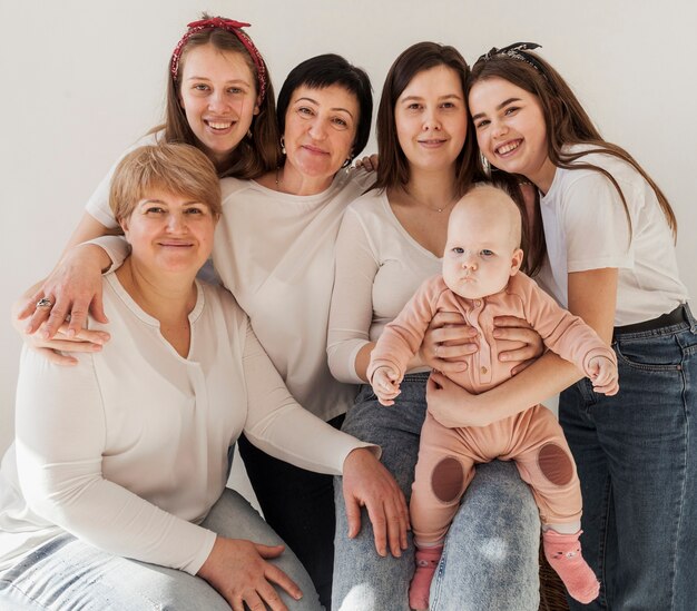 Women in white shirts posing together and baby