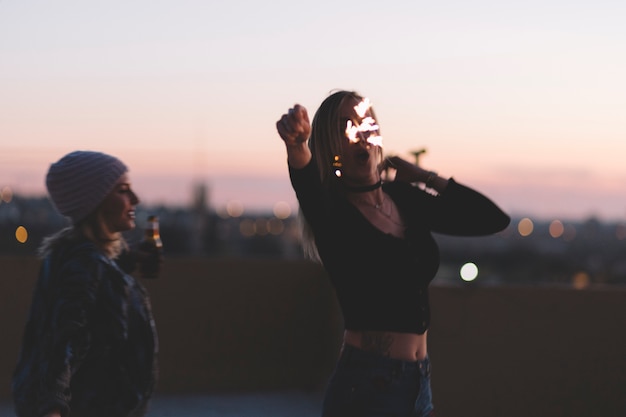 Free photo women with beer and sparklers on roof