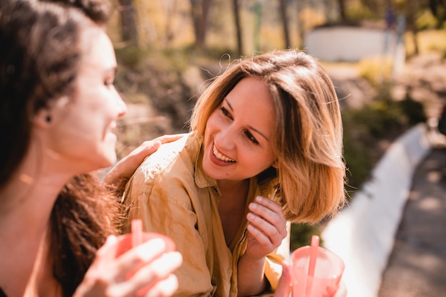 Free photo women with drinks laughing and chatting