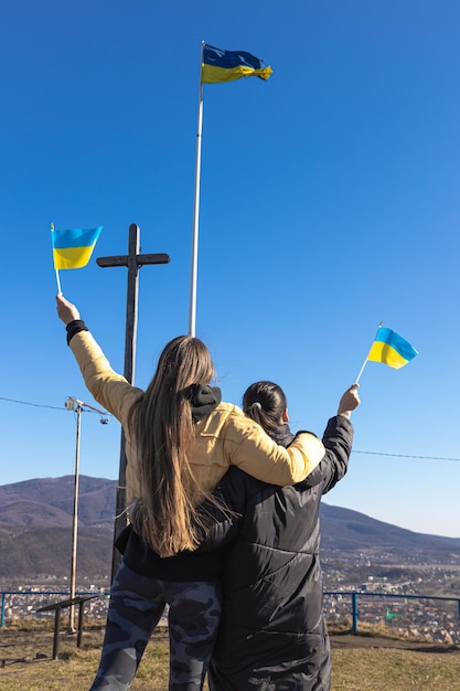 Women with flags of ukraine against the background of the sky and mountains