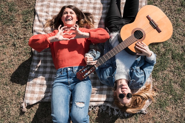 Free photo women with guitar on coverlet