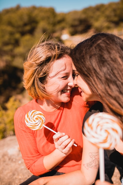 Free photo women with lollipops touching noses