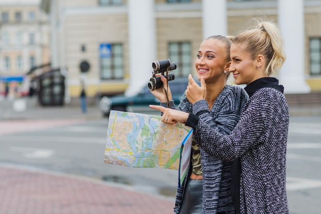 Free Photo women with map and binoculars together