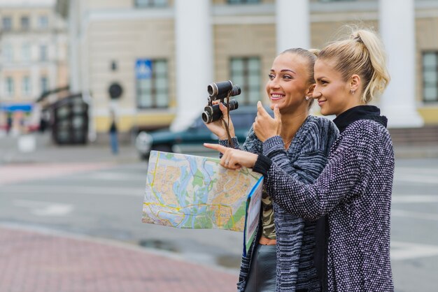 Women with map and binoculars together