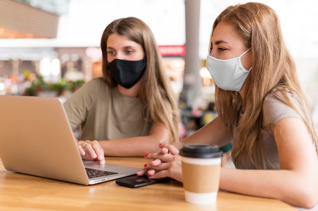 Women with mask working on laptop