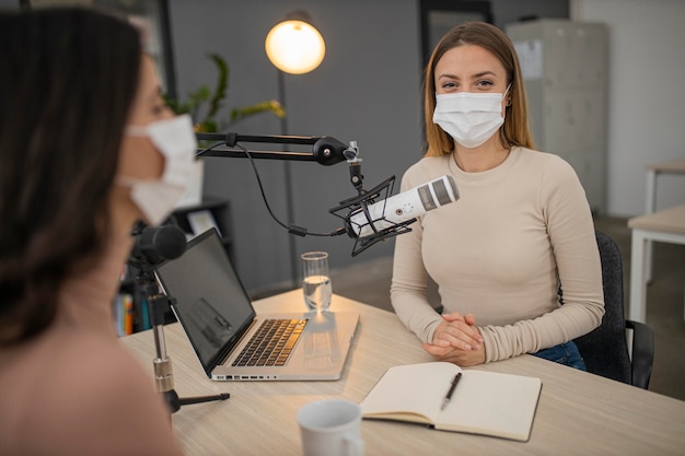 Women with medical masks in a radio studio