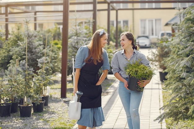 Free photo women working in a greenhouse with a flowerpots