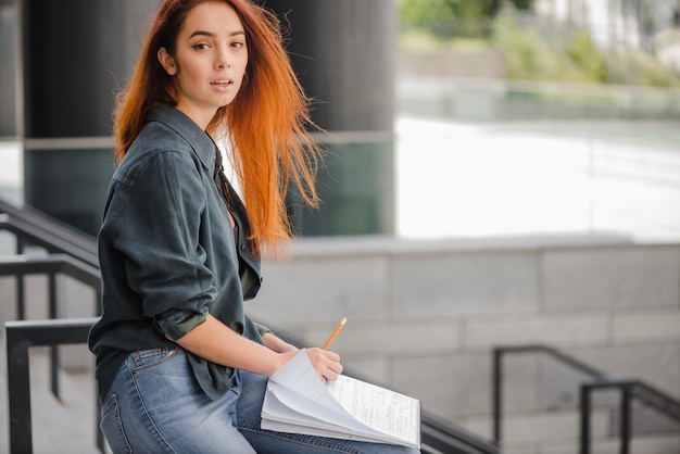 Free photo womna with papers looking at camera