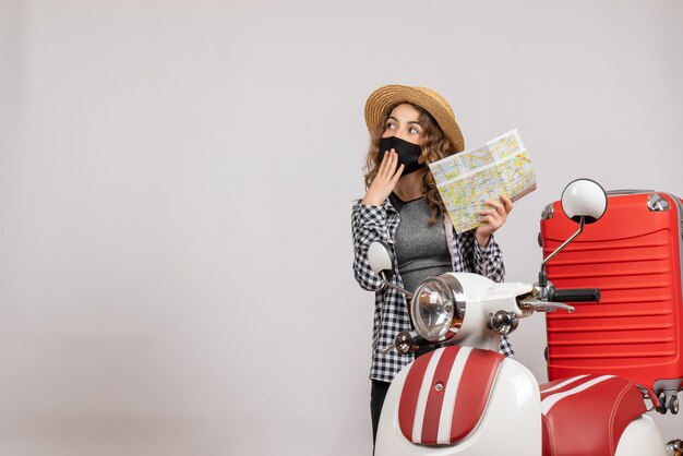 wondered young girl with black mask holding map standing near red moped