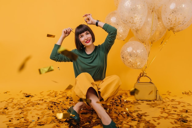 Free photo wonderful girl with hair accessory posing. ecstatic brunette lady having fun in at birthday party.