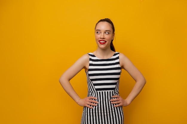 Free photo wonderful stylish girl in stripped dress posing on yellow