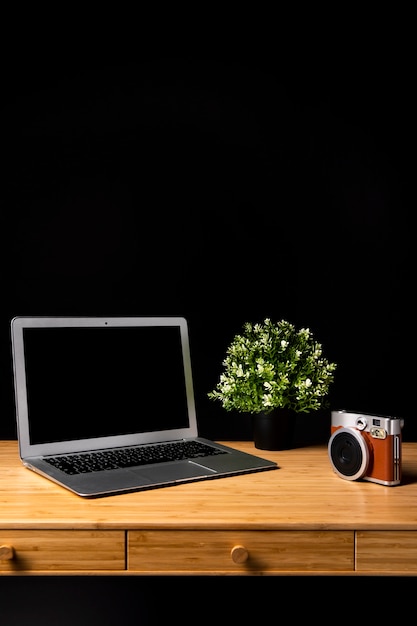 Wood desk with laptop and camera