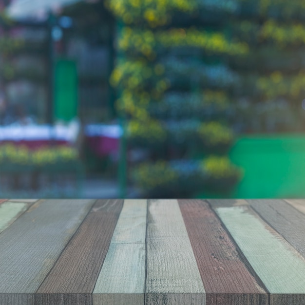 Free Photo wood table in front of blurry garden backdrop