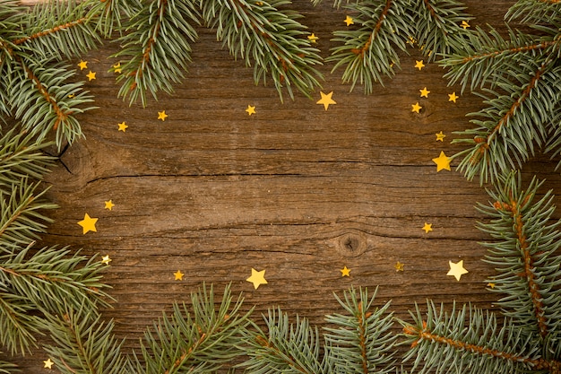 Wooden background with pine leaves and stars