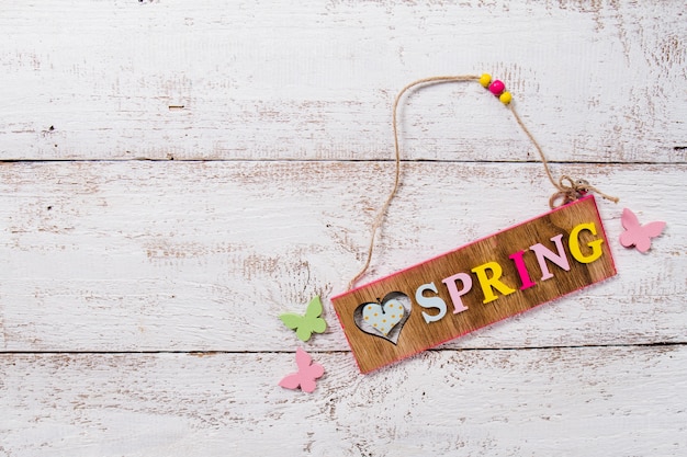 Free photo wooden background with spring sign and decorative butterflies