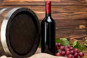 Free photo wooden barrel with bottle and glass of wine