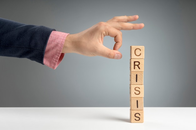 Free photo wooden blocks with crisis mesage on desk