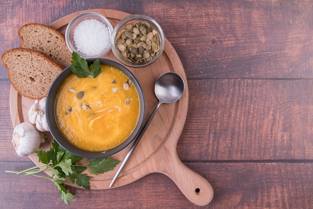 Wooden board filled with bowl of soup and ingredients