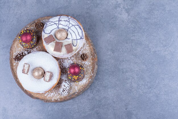 A wooden board full of cakes with sugar powder