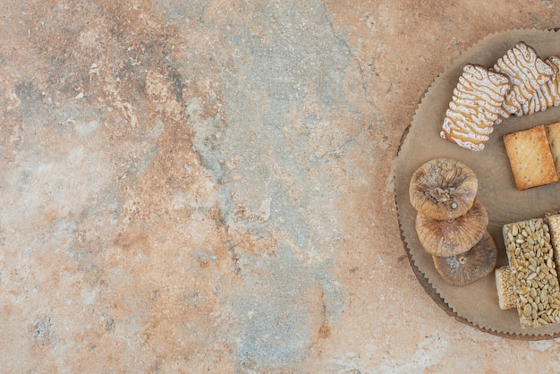 A wooden board full of sweet cookies and peanut brittles