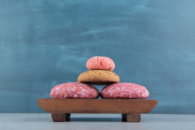 A wooden board full of sweet cookies .  