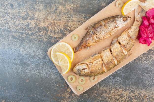 Free photo a wooden board of sliced fish with lemon and cabbage . high quality photo