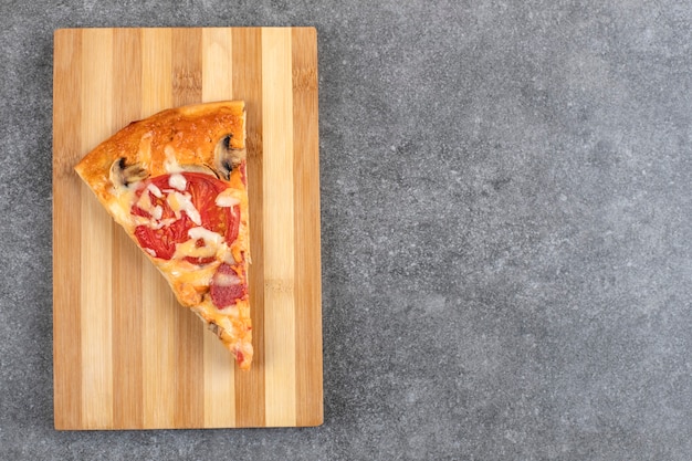 Wooden board of tasty homemade pizza on stone table.