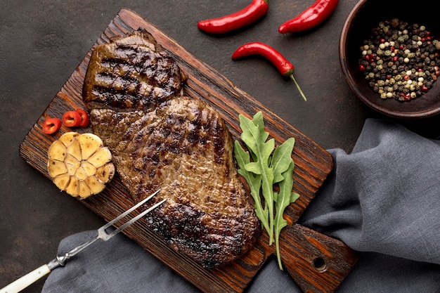 Free Photo wooden board with grilled meat and seasoning