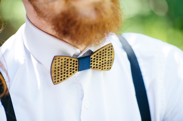 Free photo wooden bow tie put over the white shirt under red beard