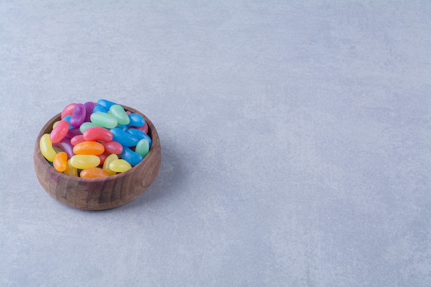 Free photo a wooden bowl of colorful sweet jelly bean candies . high quality photo