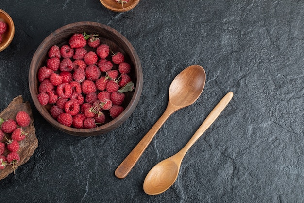 Wooden bowl of delicious red raspberries