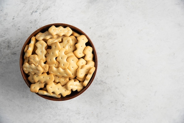 A wooden bowl full of delicious crackers .