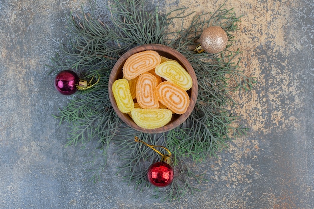 A wooden bowl full of fruit jelly orange and yellow candies. High quality photo