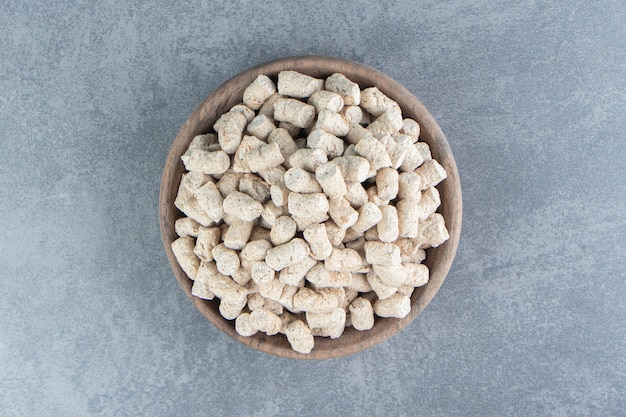 A wooden bowl full of rye crispy cereals .